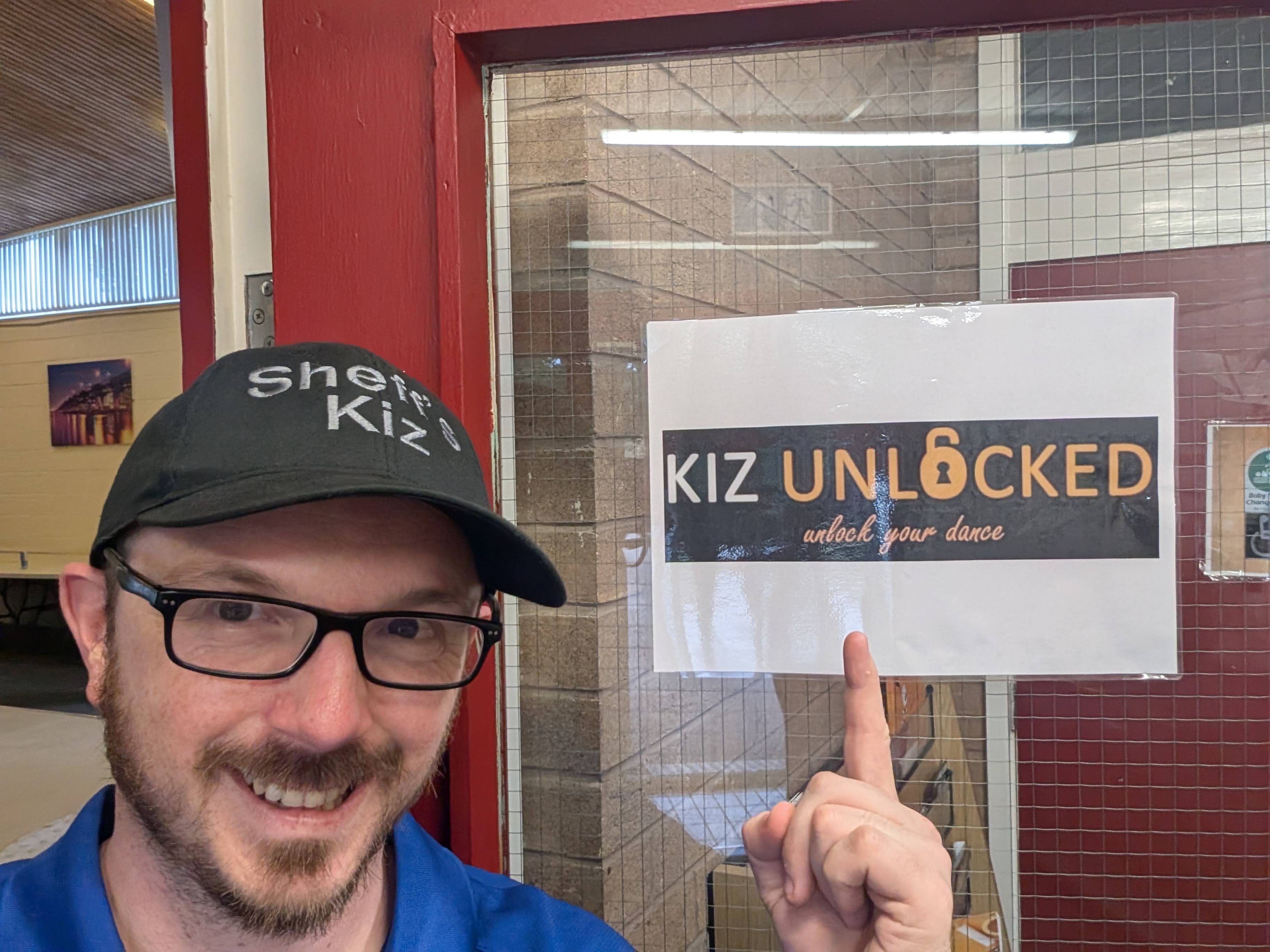 Dancer in a Sheff's Kiz cap pointing at a Kiz Unlocked studio door